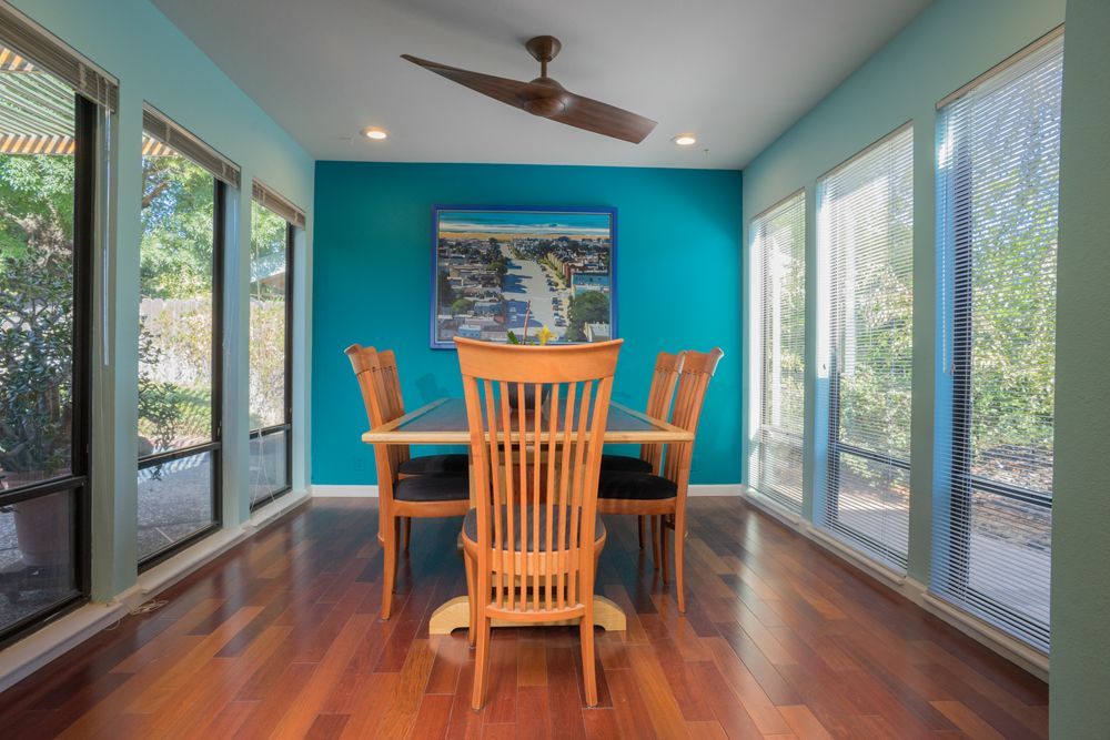 A dining room with a table and chairs and a ceiling fan