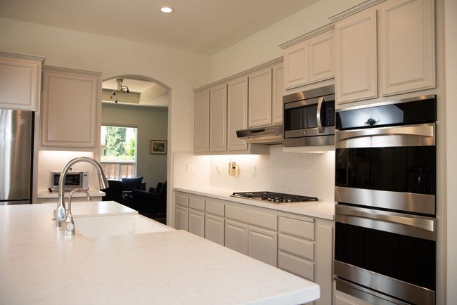 A kitchen with white cabinets and stainless steel appliances.