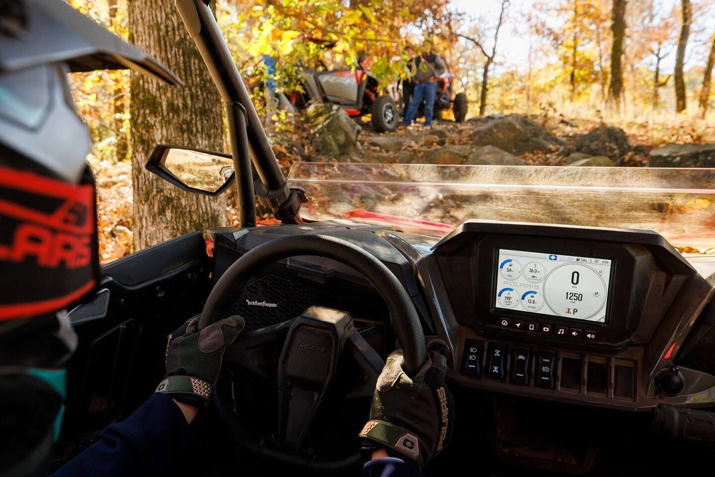 A person is driving a atv on a dirt road in the woods.