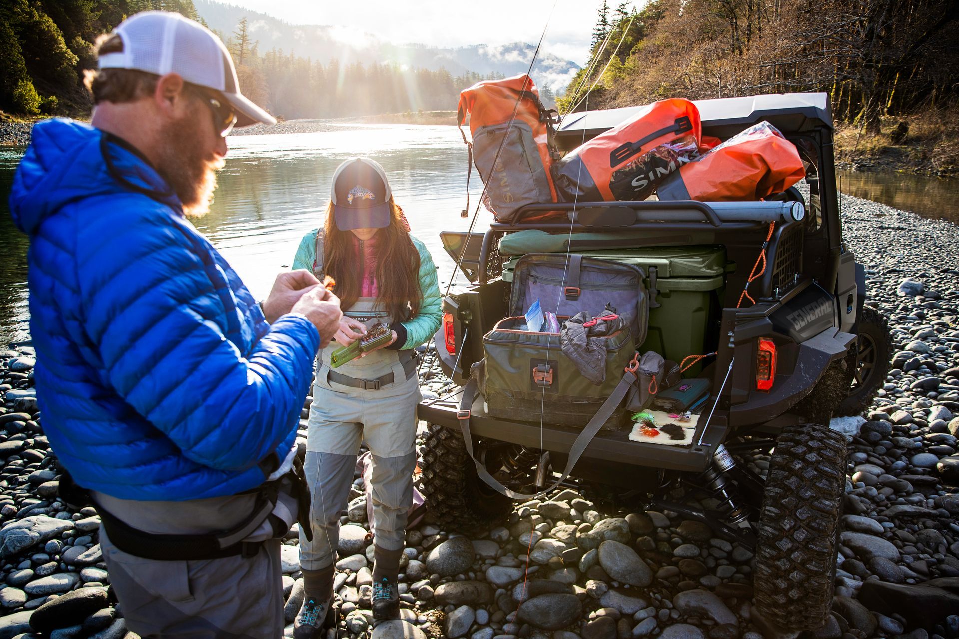 A man and a woman are standing next to a vehicle.