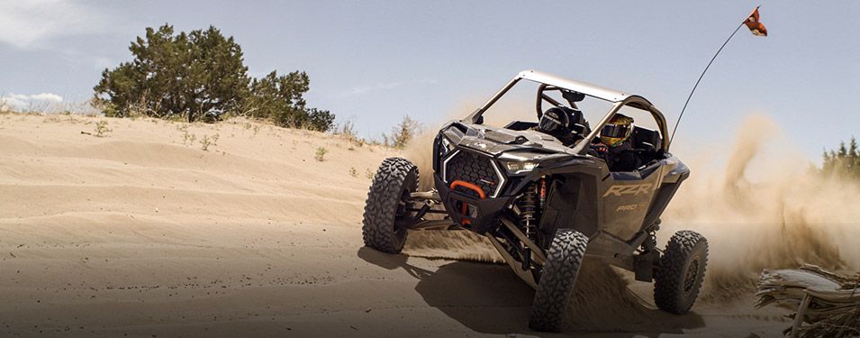 A person is driving a atv on a dirt road.