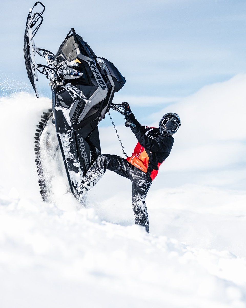 A man is riding a snowmobile in the snow.