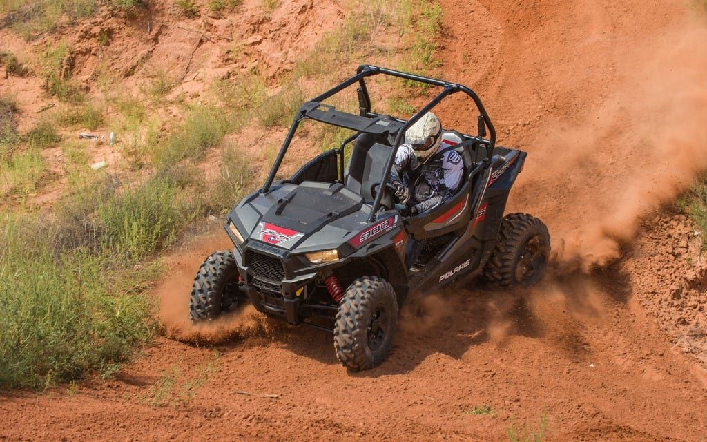 A person is riding a atv on a dirt road.