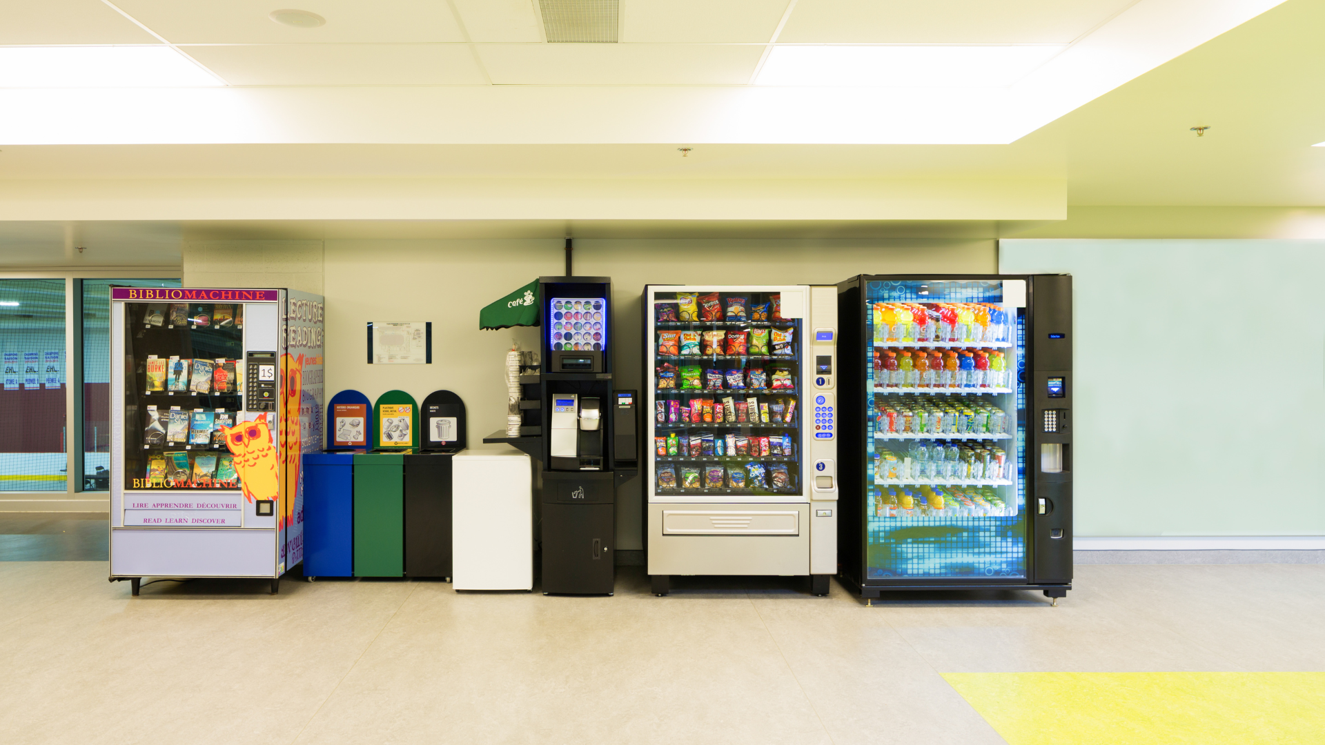 Hands using pliers and a screwdriver to repair a broken vending machine inside an open case.
