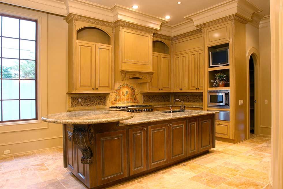 A luxury kitchen with a central island, granite countertops, warm-toned wood cabinets, and large windowed walls.