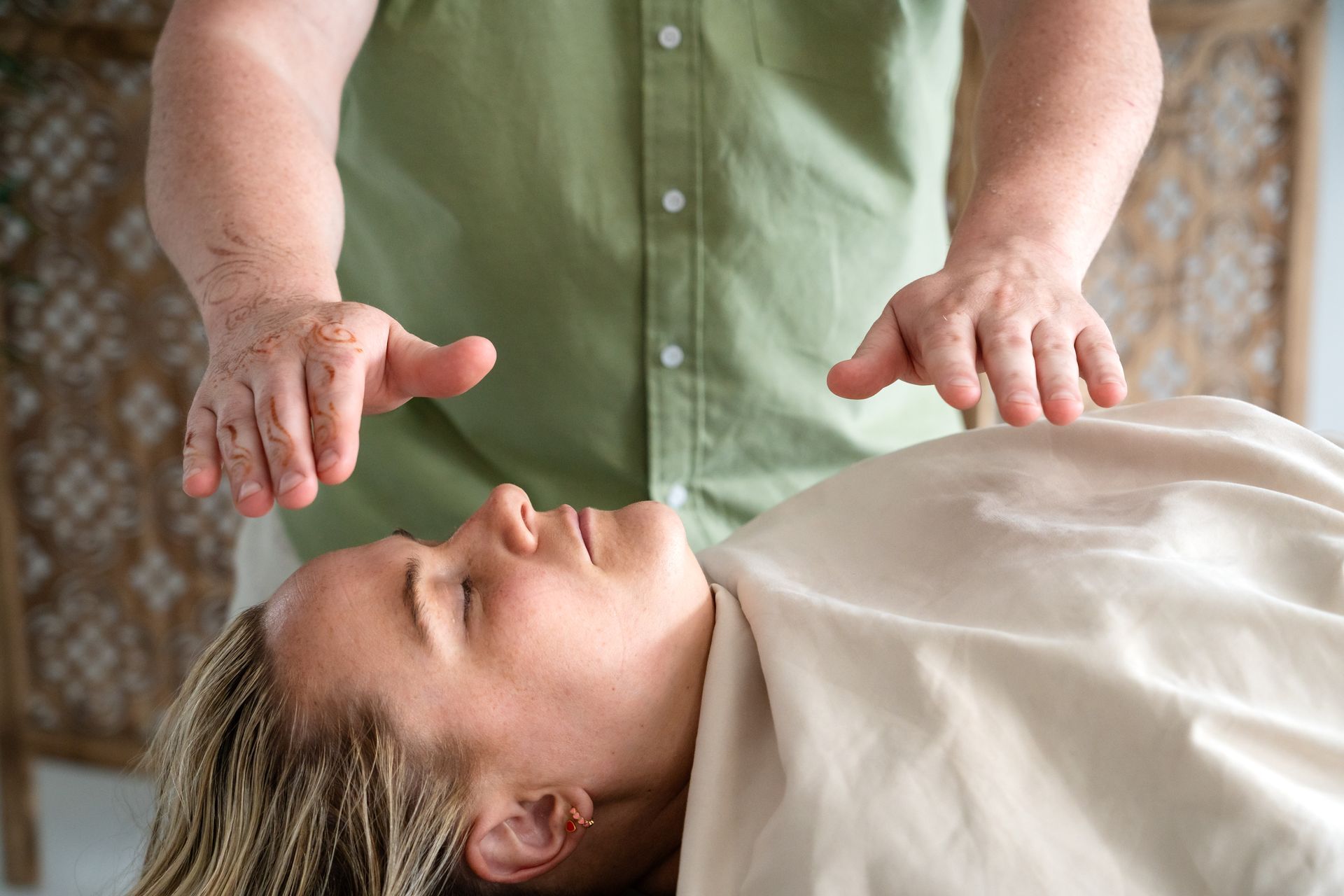 Person in lotus pose, forming tree with arms and leaves, within oval watercolor background.