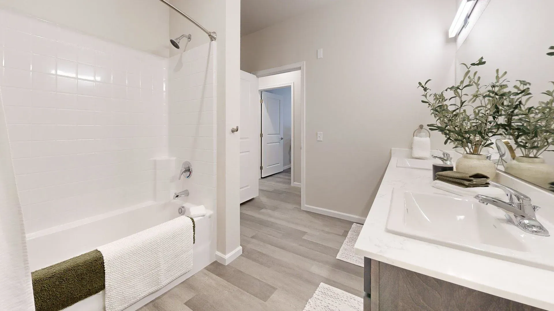 A bathroom with a tub , sink and mirror.