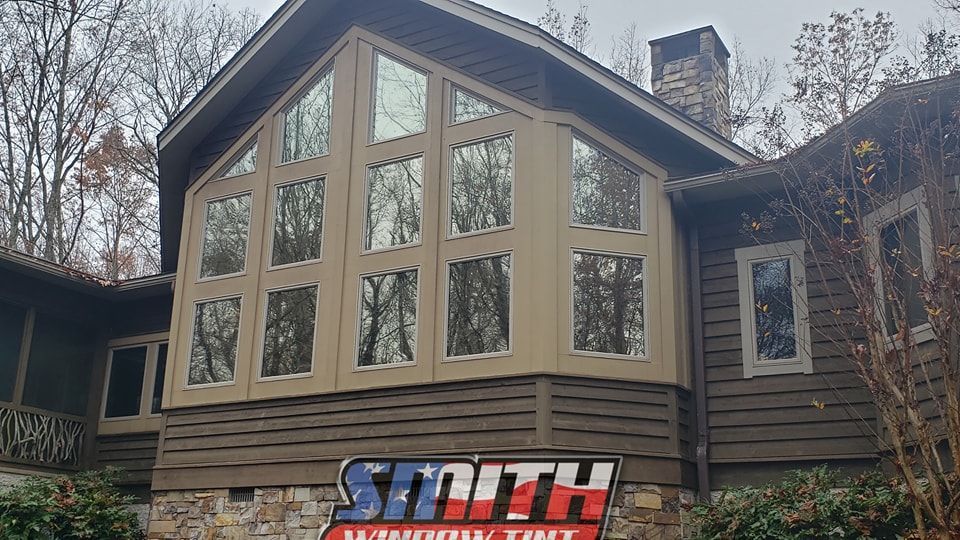 A bench is sitting in front of a building with a lot of windows.