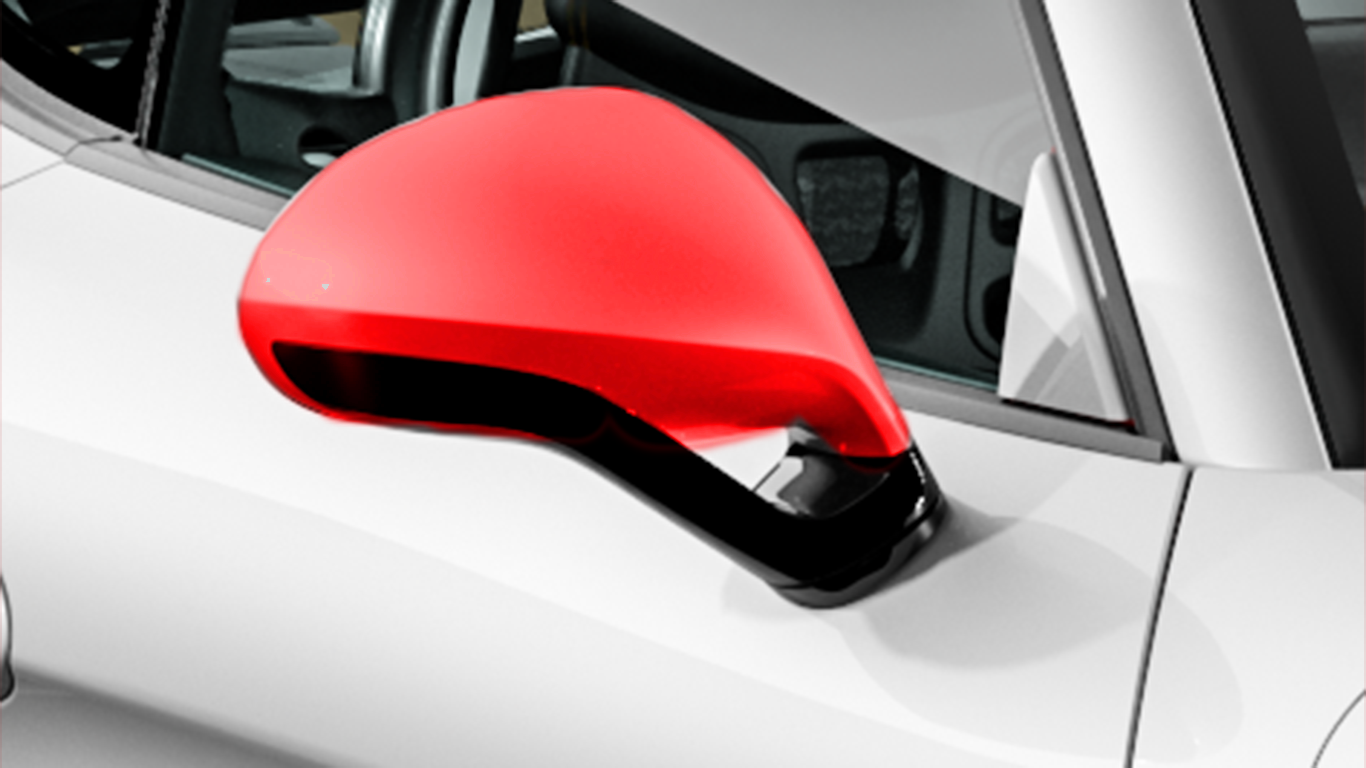 A close up of a red side mirror on a white car