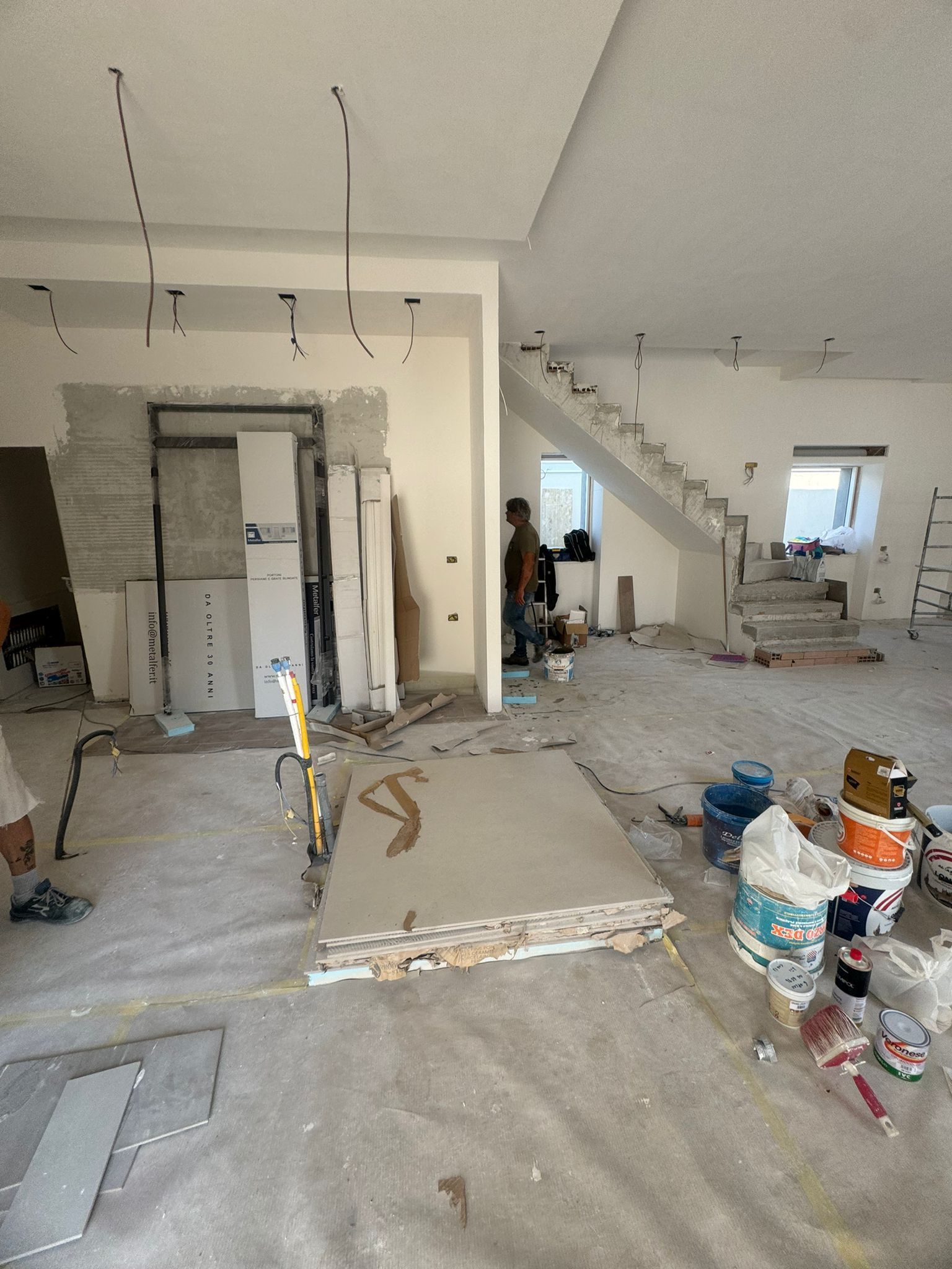 Una grande stanza con una scala è in fase di ristrutturazione.