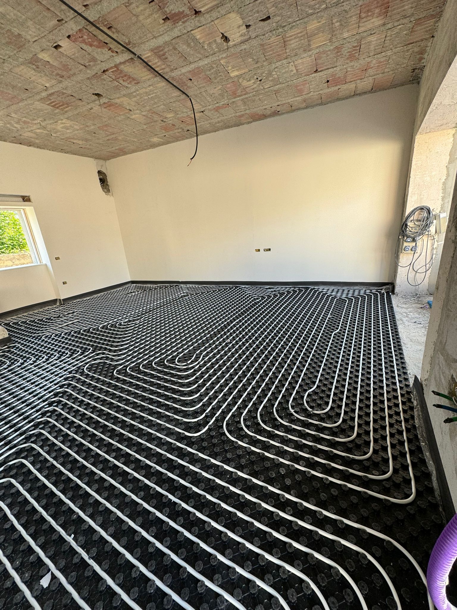 Una stanza con un sistema di riscaldamento a pavimento in bianco e nero.