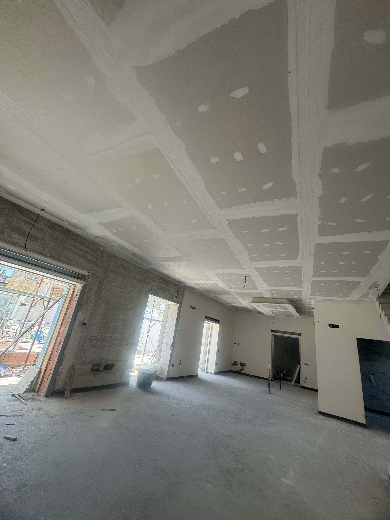 Una grande stanza vuota con un soffitto in fase di ristrutturazione.