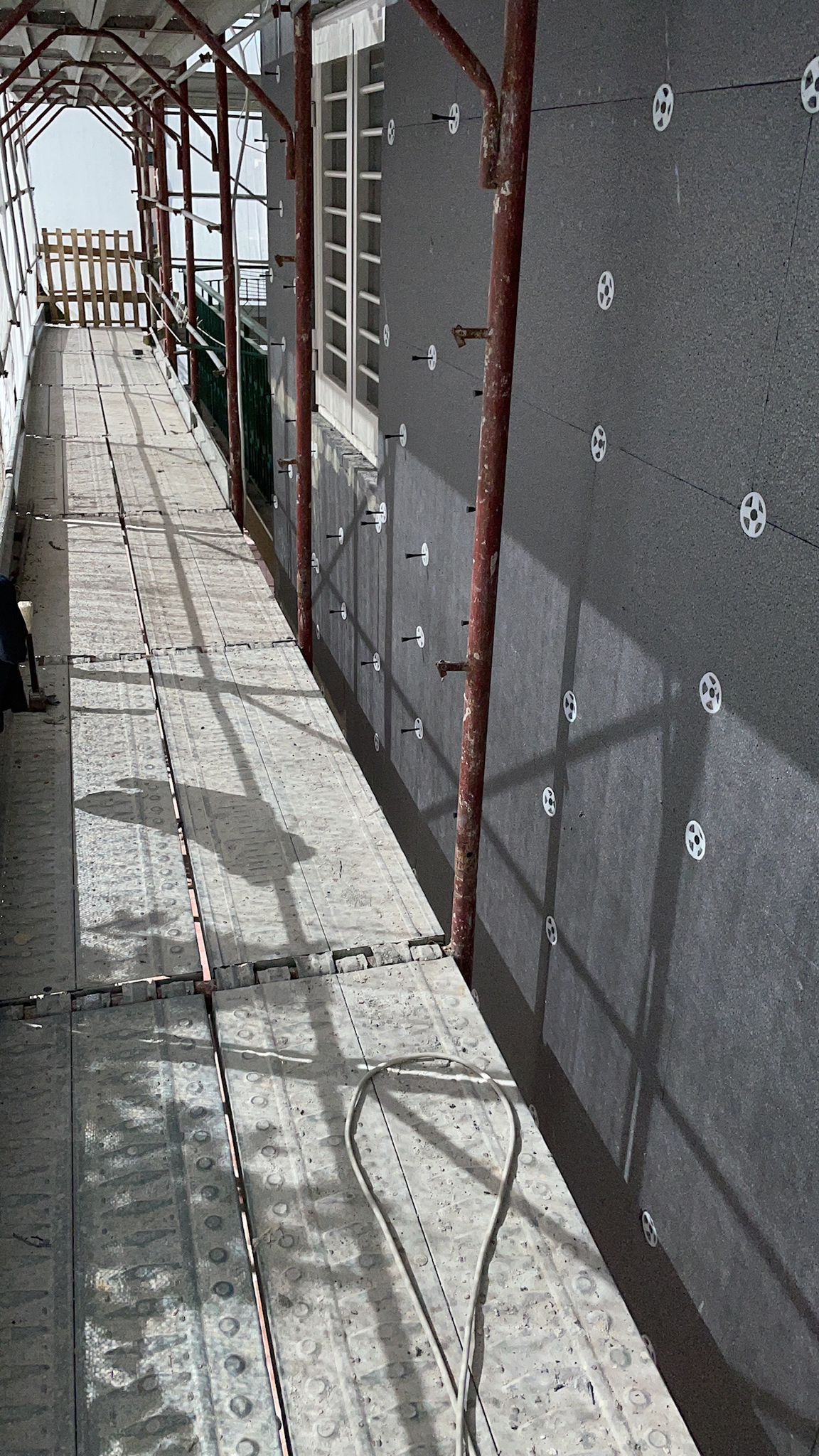 Una fila di impalcature lungo il lato di un edificio in costruzione.