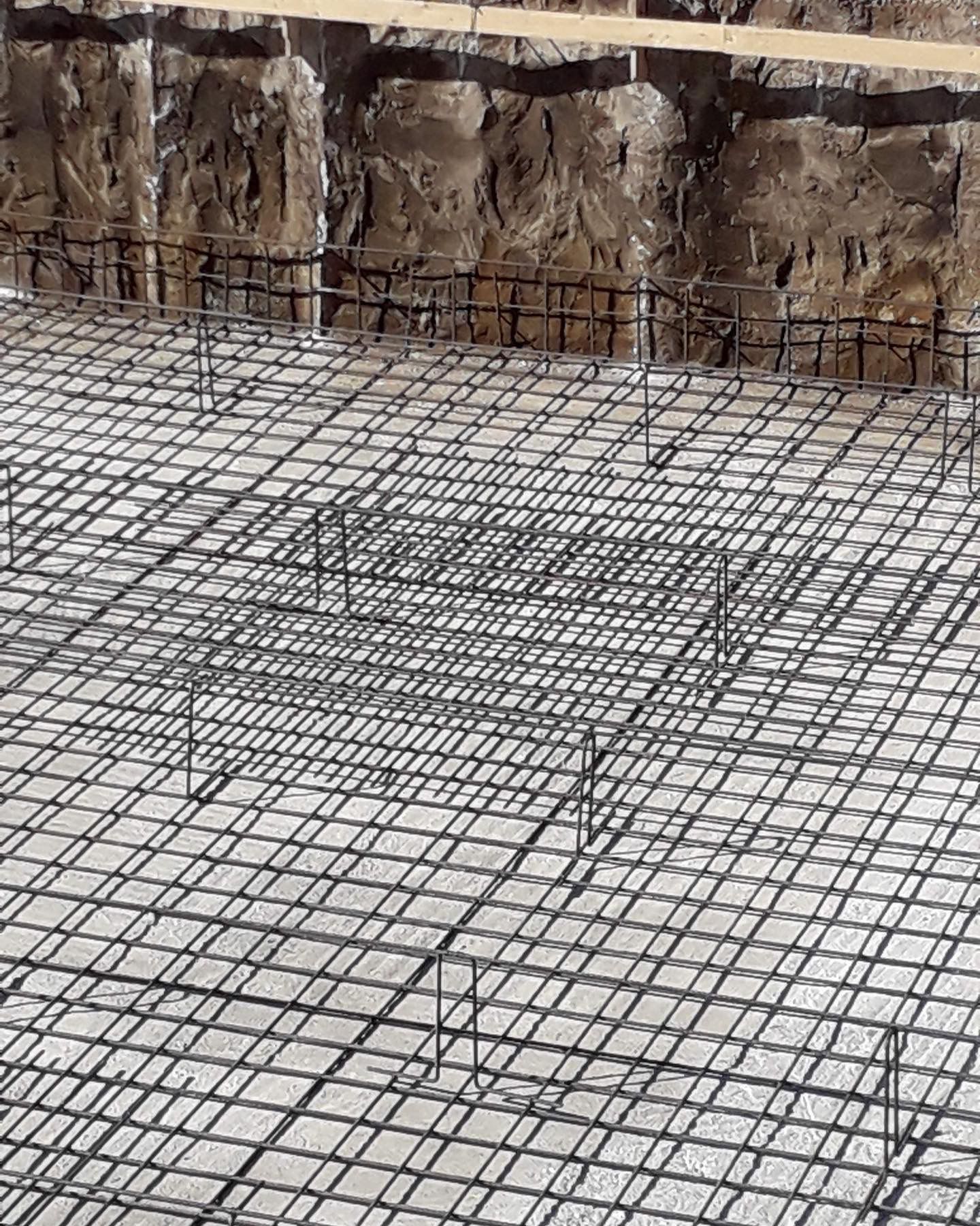 Un primo piano di un pavimento in cemento con una rete metallica.