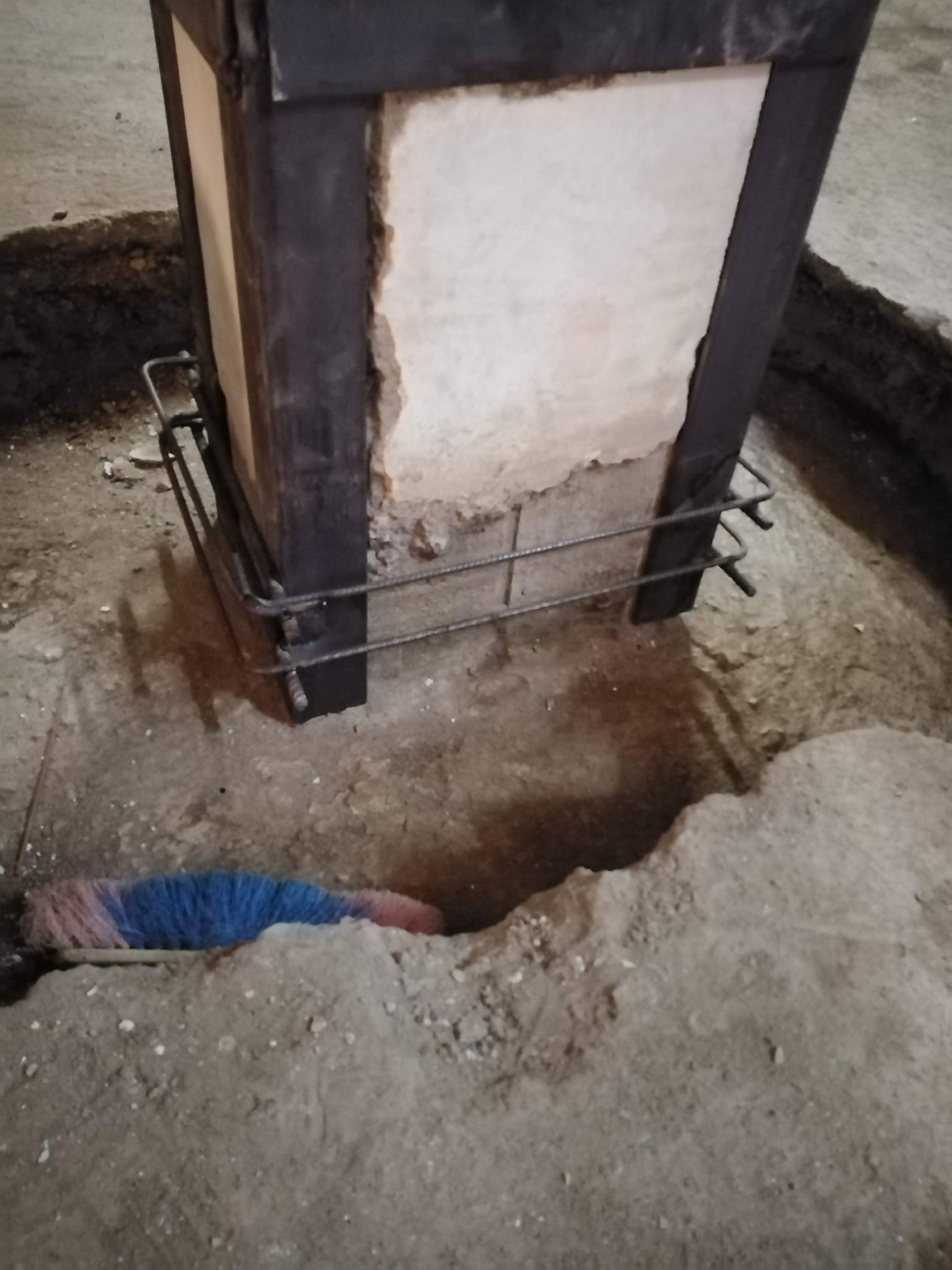 Una persona è sdraiata nella terra accanto a un camino.