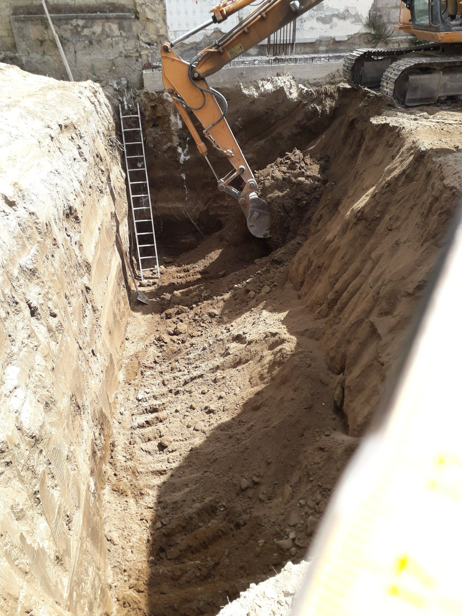 Un grande escavatore sta scavando una buca nel terreno.