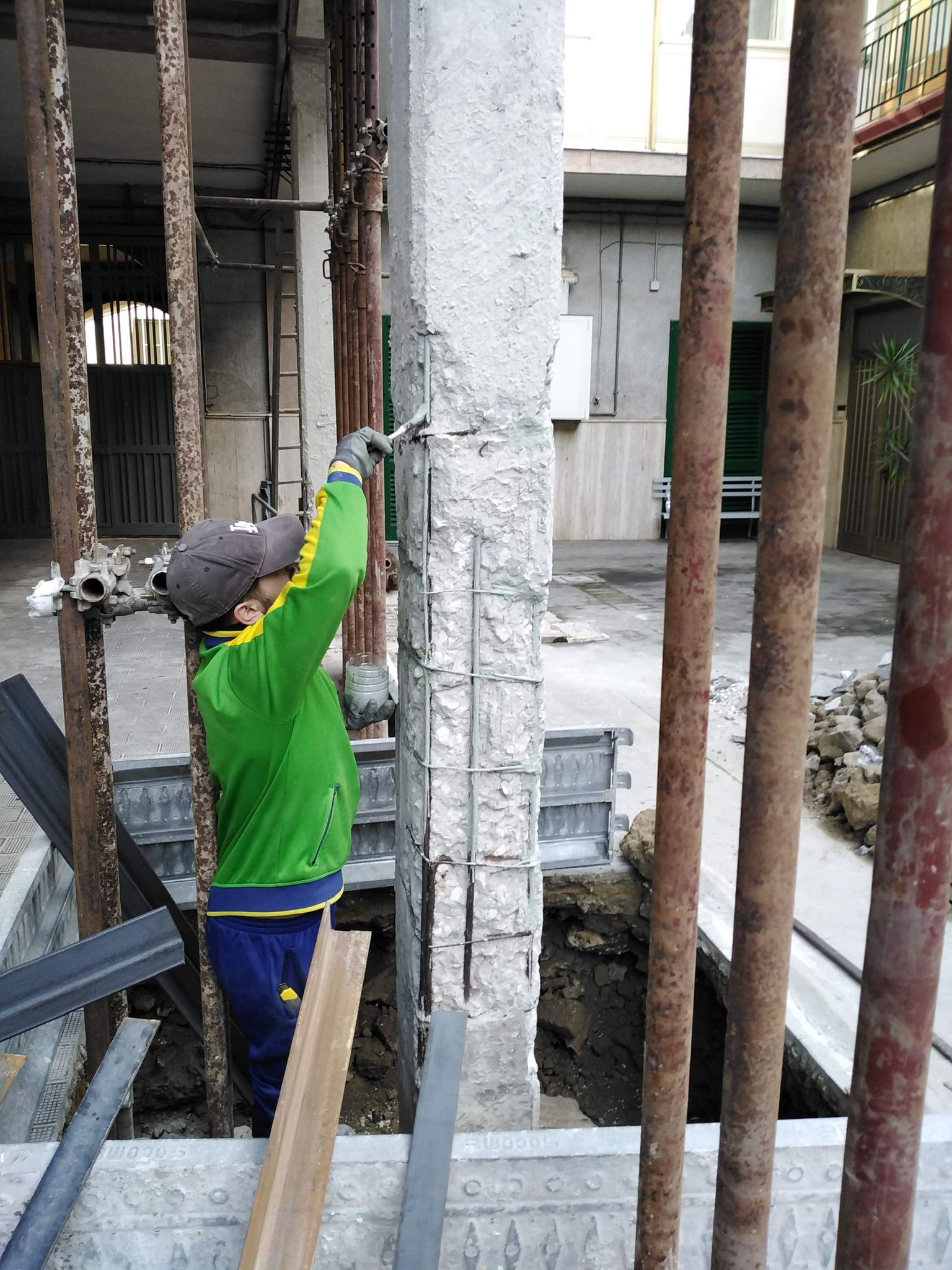 Un uomo con una giacca verde sta lavorando in un cantiere edile.