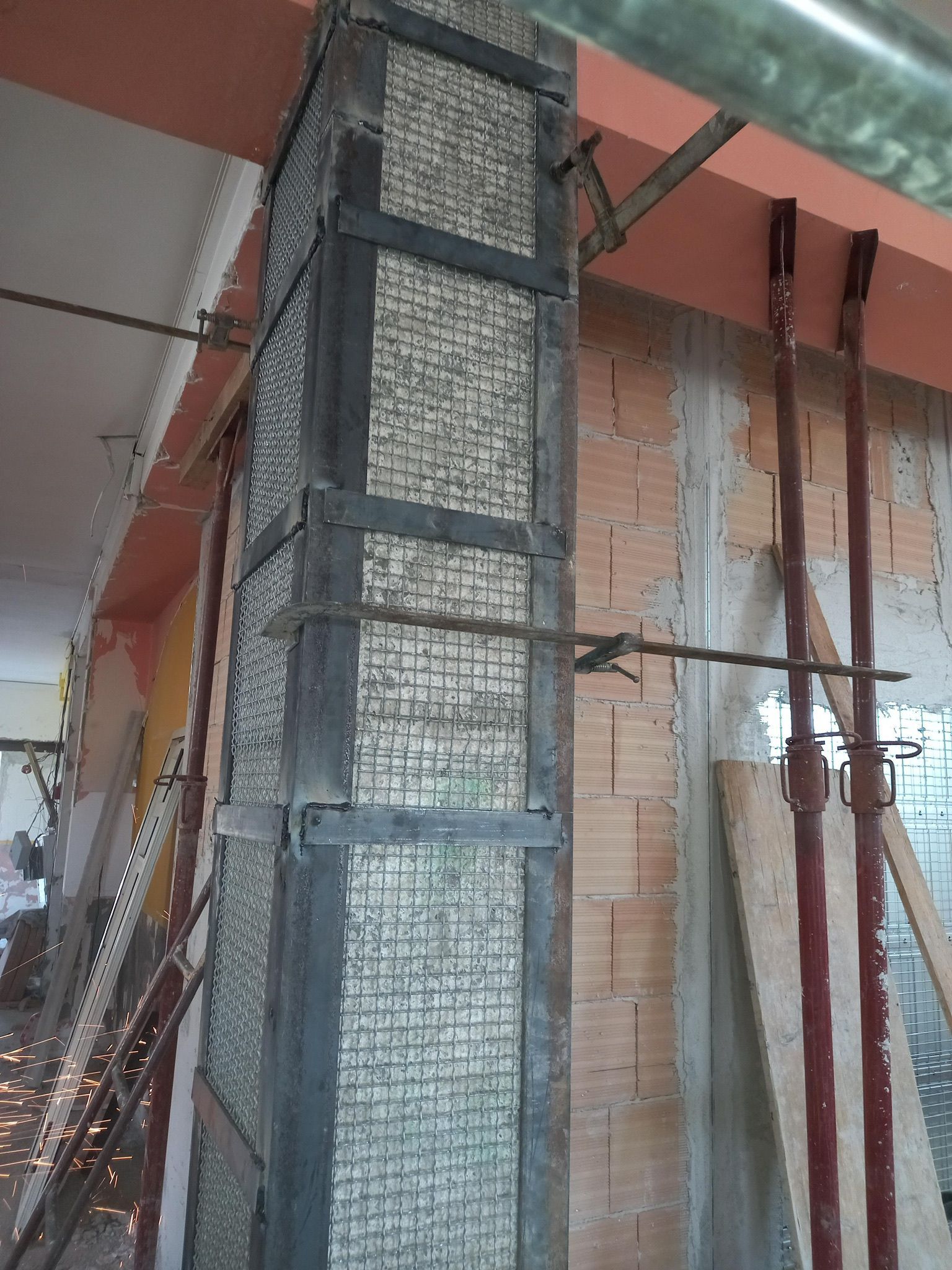 Un muro di mattoni con una trave di metallo attaccata