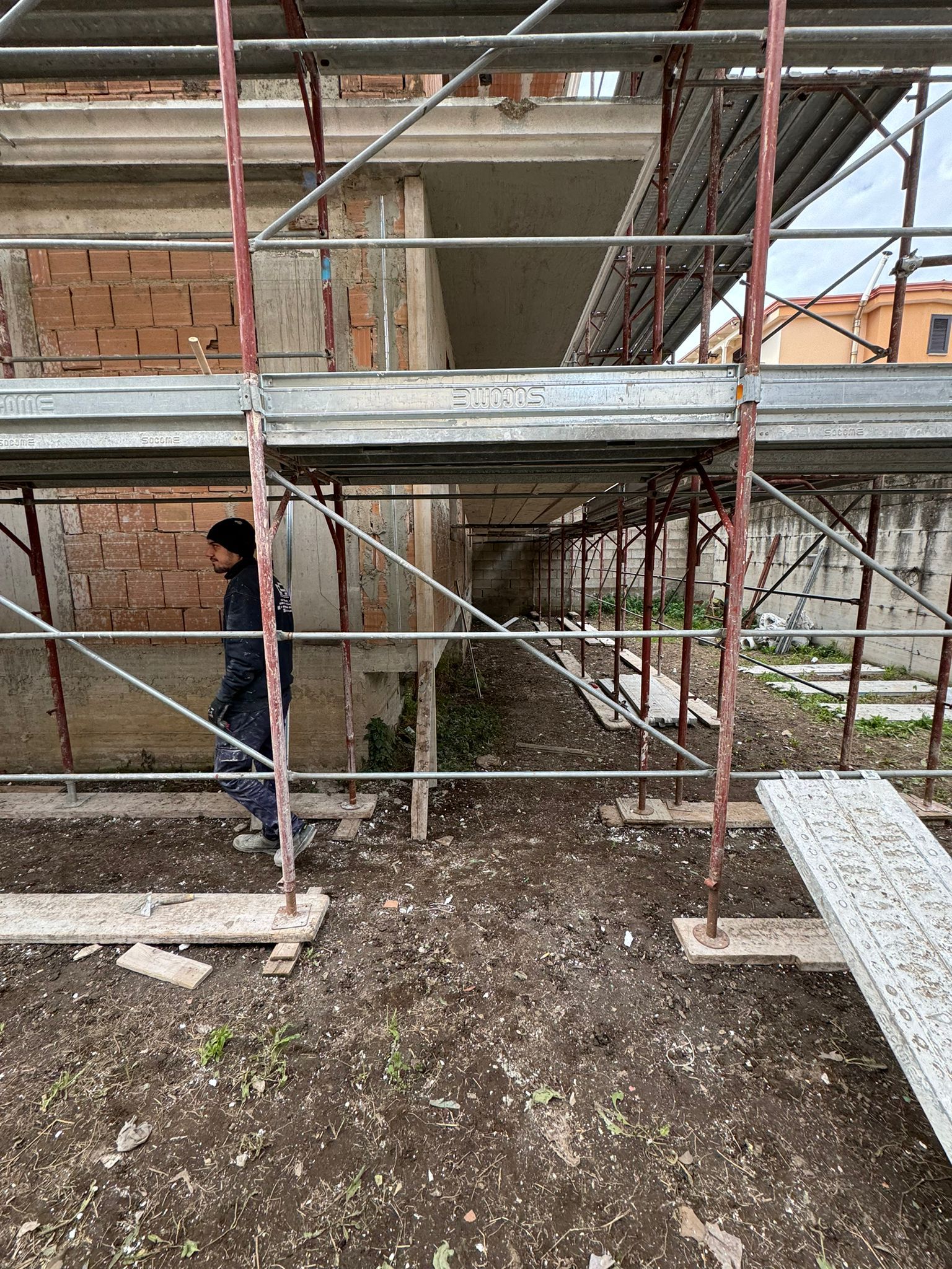 Un uomo è in piedi davanti a un edificio in costruzione.