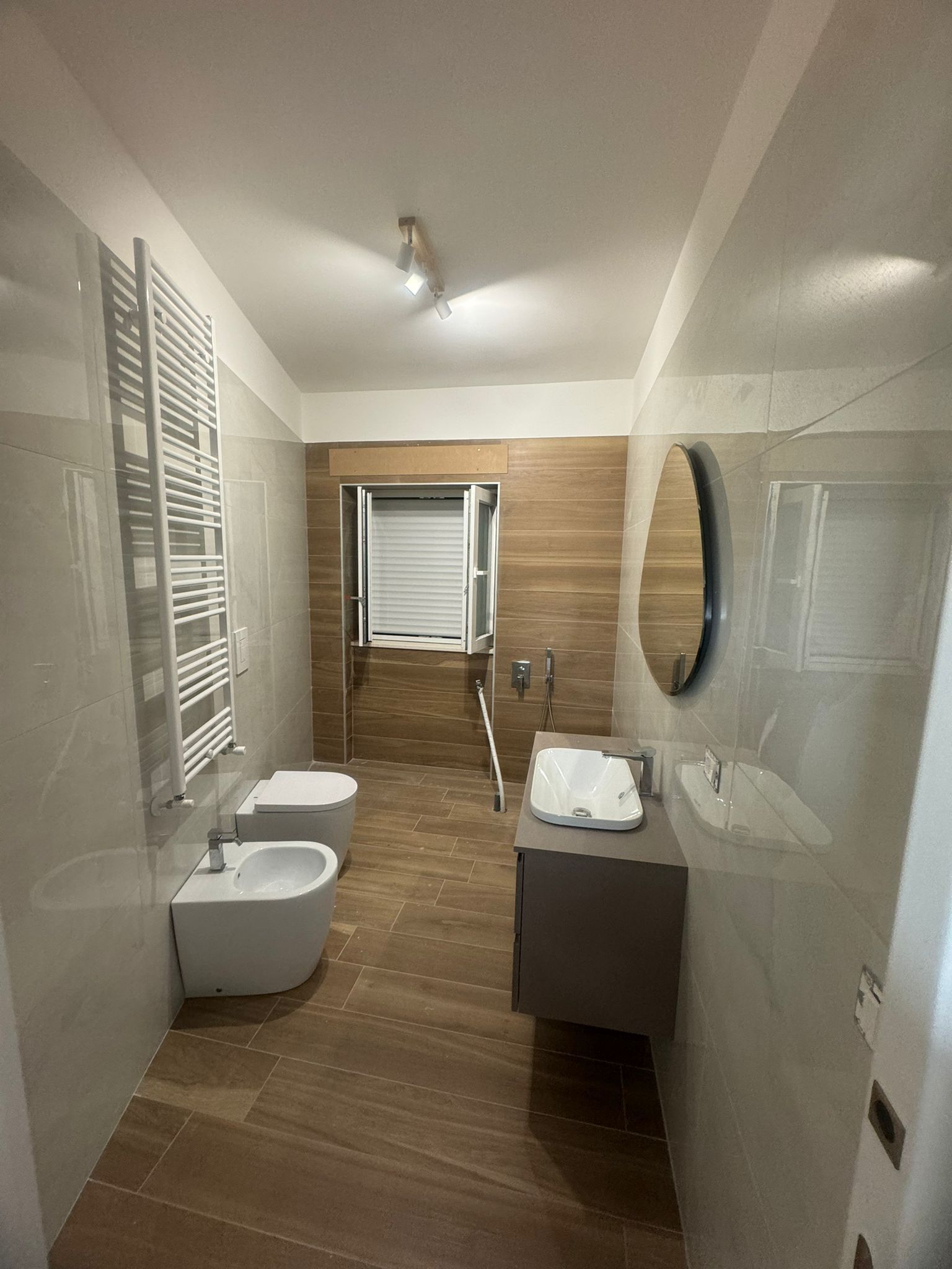 Un bagno con due water, un lavandino e uno specchio.