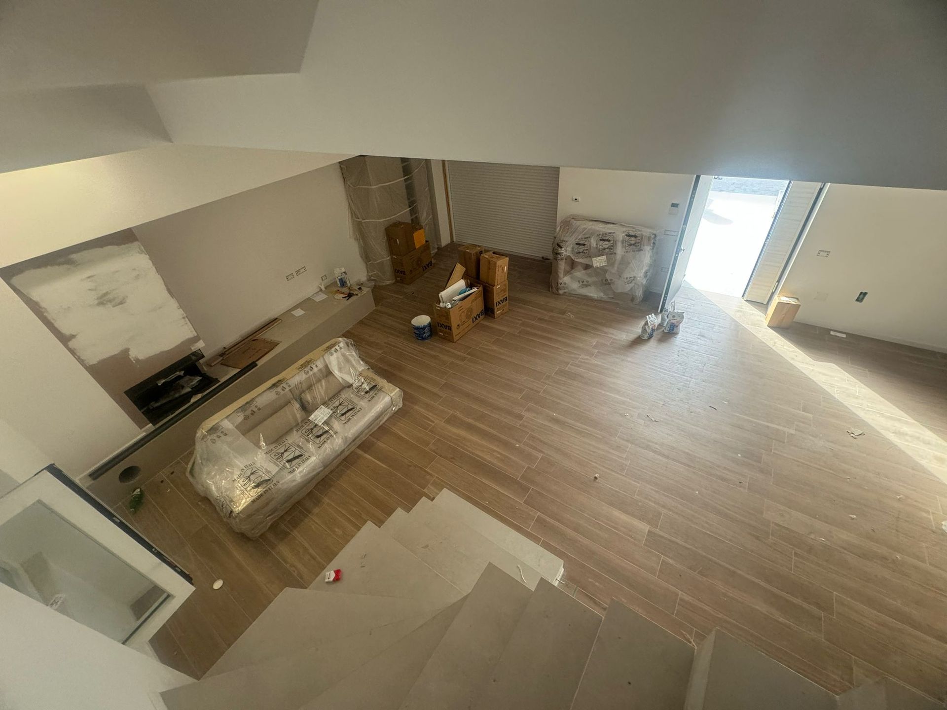 Una vista aerea di un soggiorno con pavimenti in legno e scale.