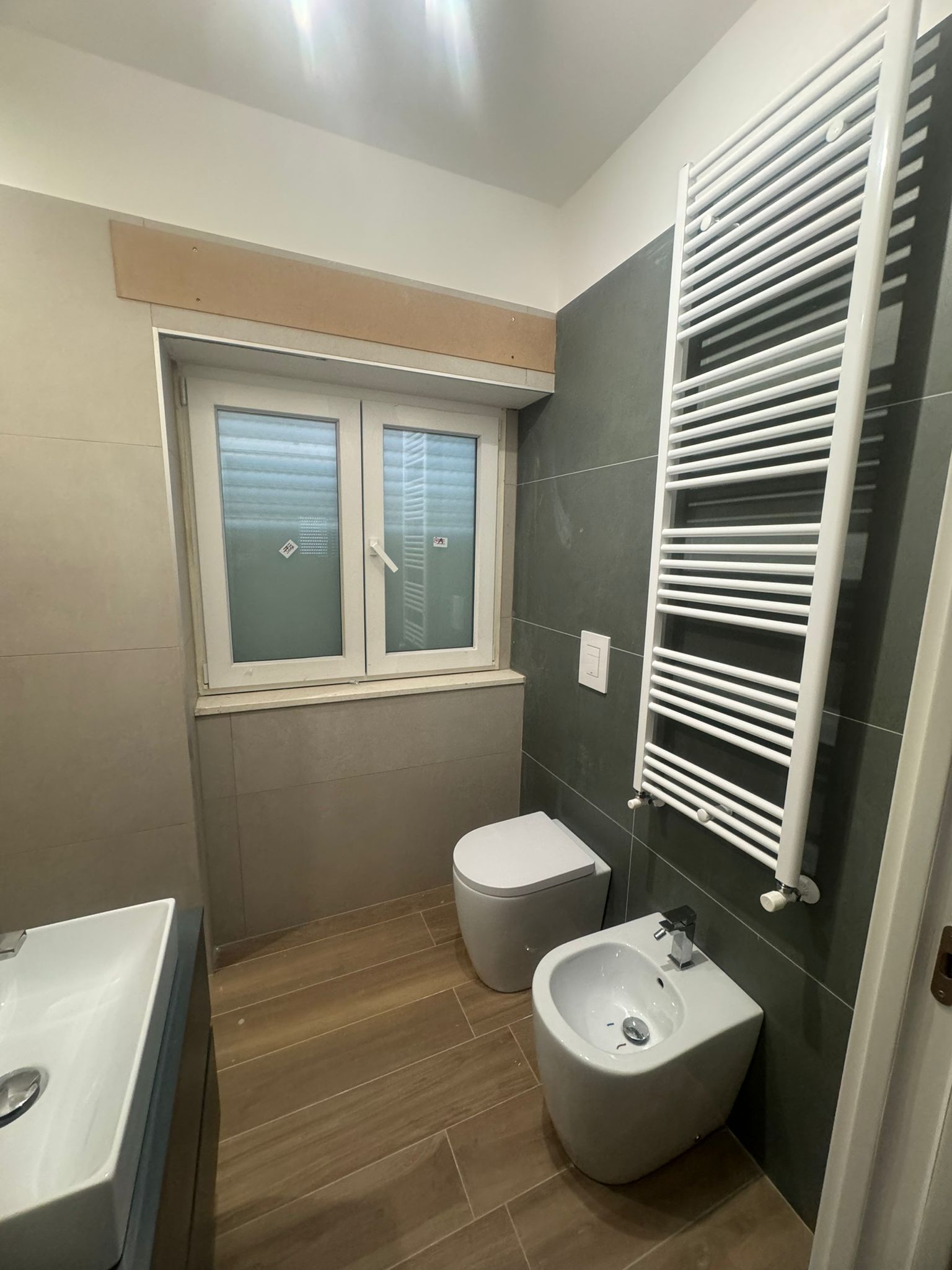 Un bagno con wc, bidet, lavandino e portasciugamani.