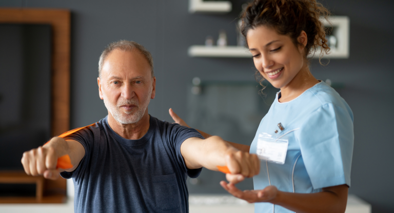 A nurse is helping an elderly man with exercises.