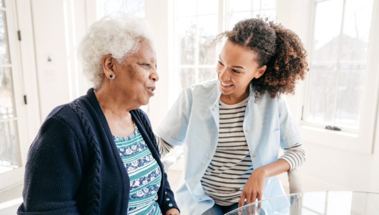 A young woman is talking to an older woman in a kitchen.