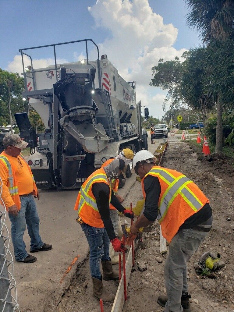 A group of construction workers are working on a road.