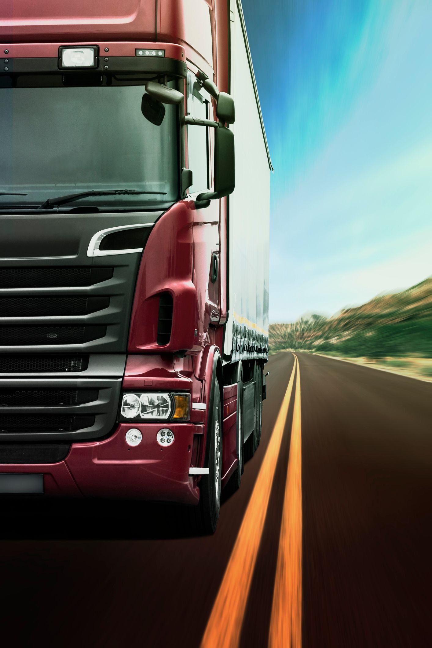 Un autoarticolato percorre un'autostrada al tramonto.