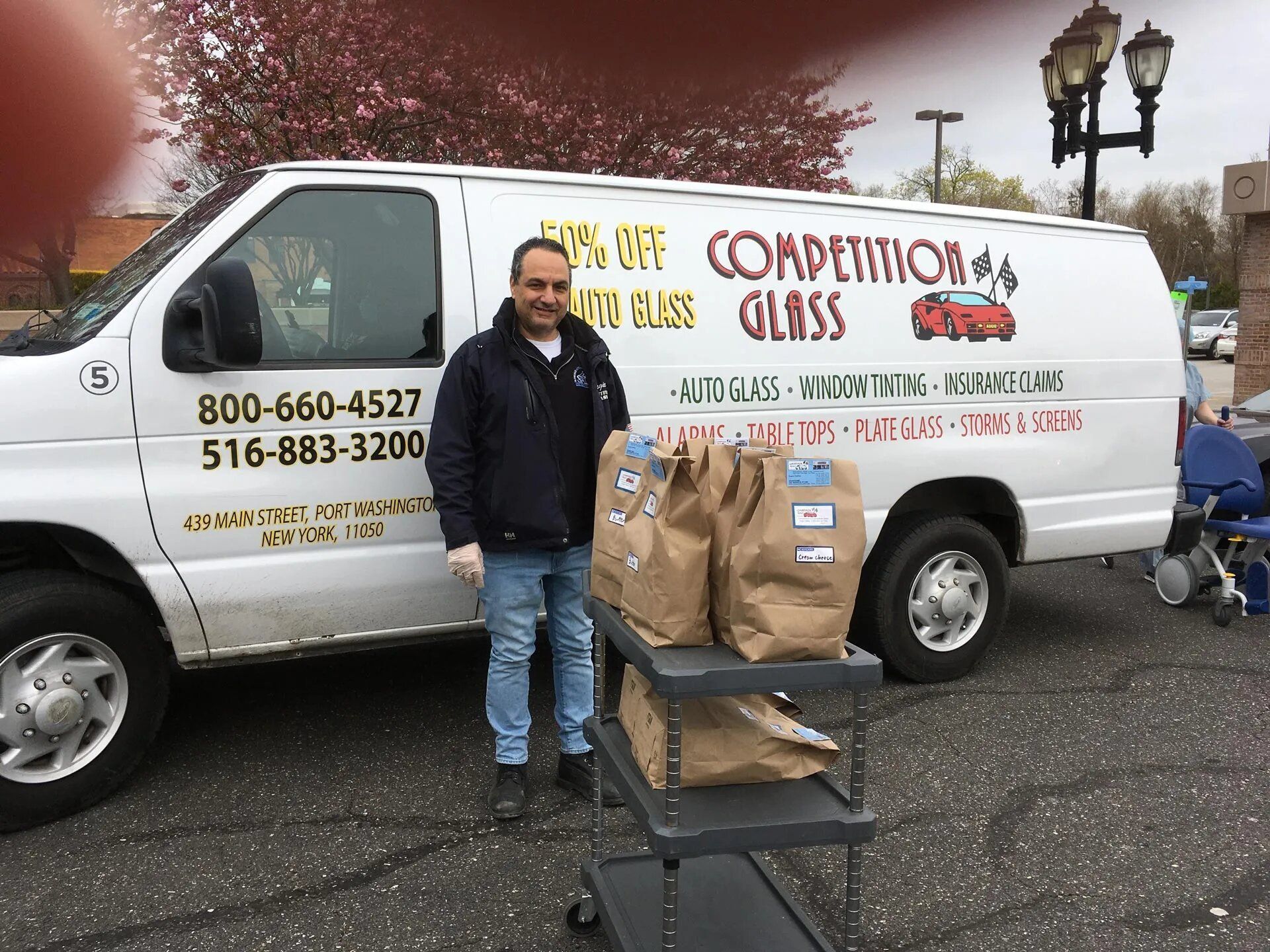 Man with Paper Bags Outside Van — Port Washington, NY — Competition Glass Inc