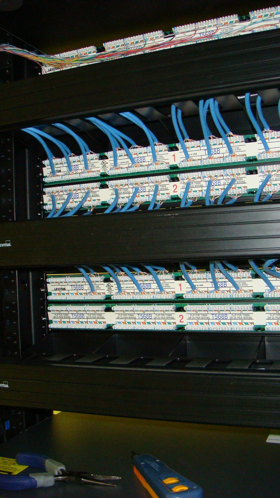 Network server rack with blue cables neatly routed to patch panels.