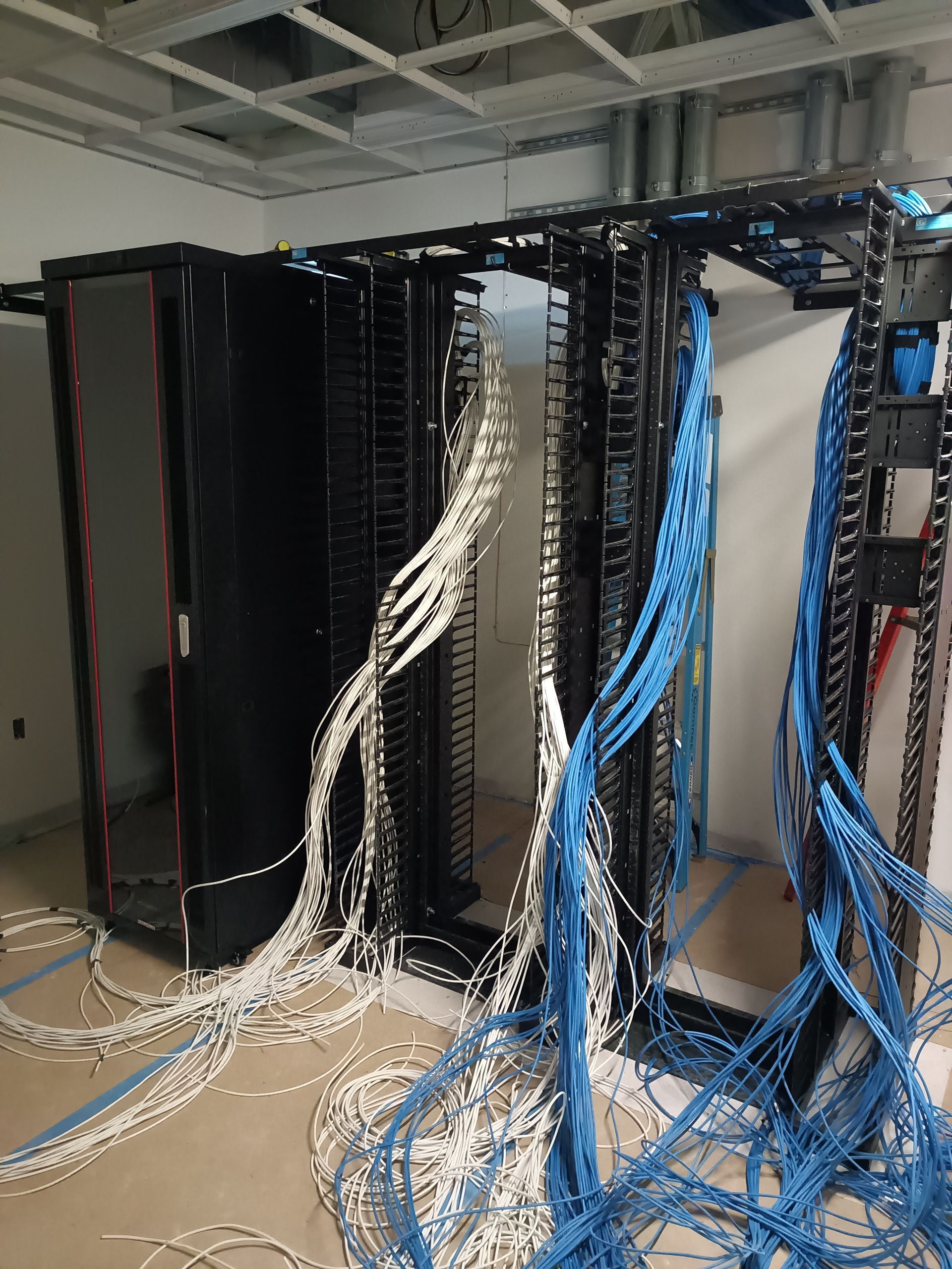 Server rack with white and blue network cables.