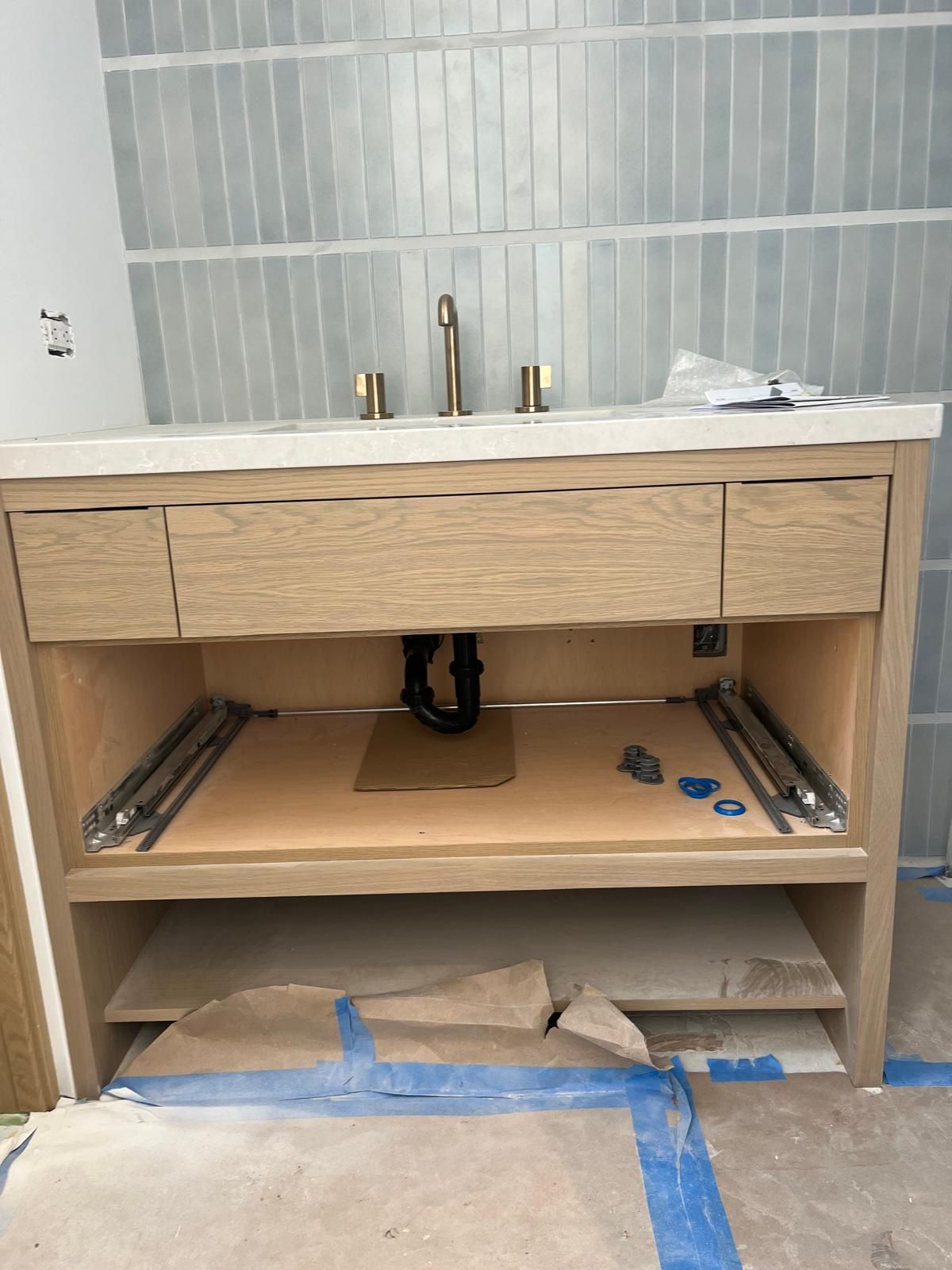 A bathroom vanity with a sink underneath it is being built.