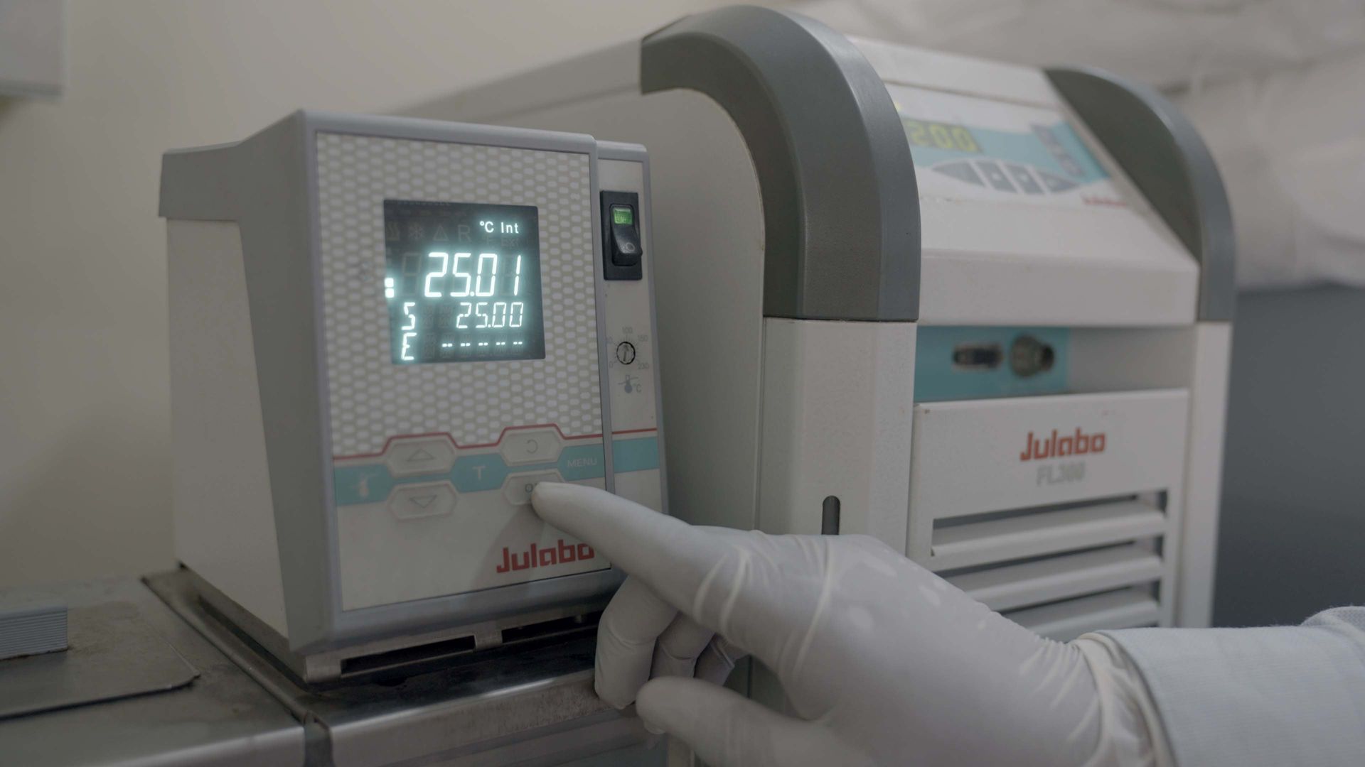 A person wearing white gloves is pressing a button on a machine.