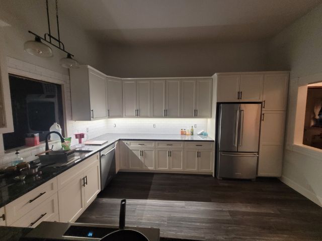 A kitchen with white cabinets and stainless steel appliances