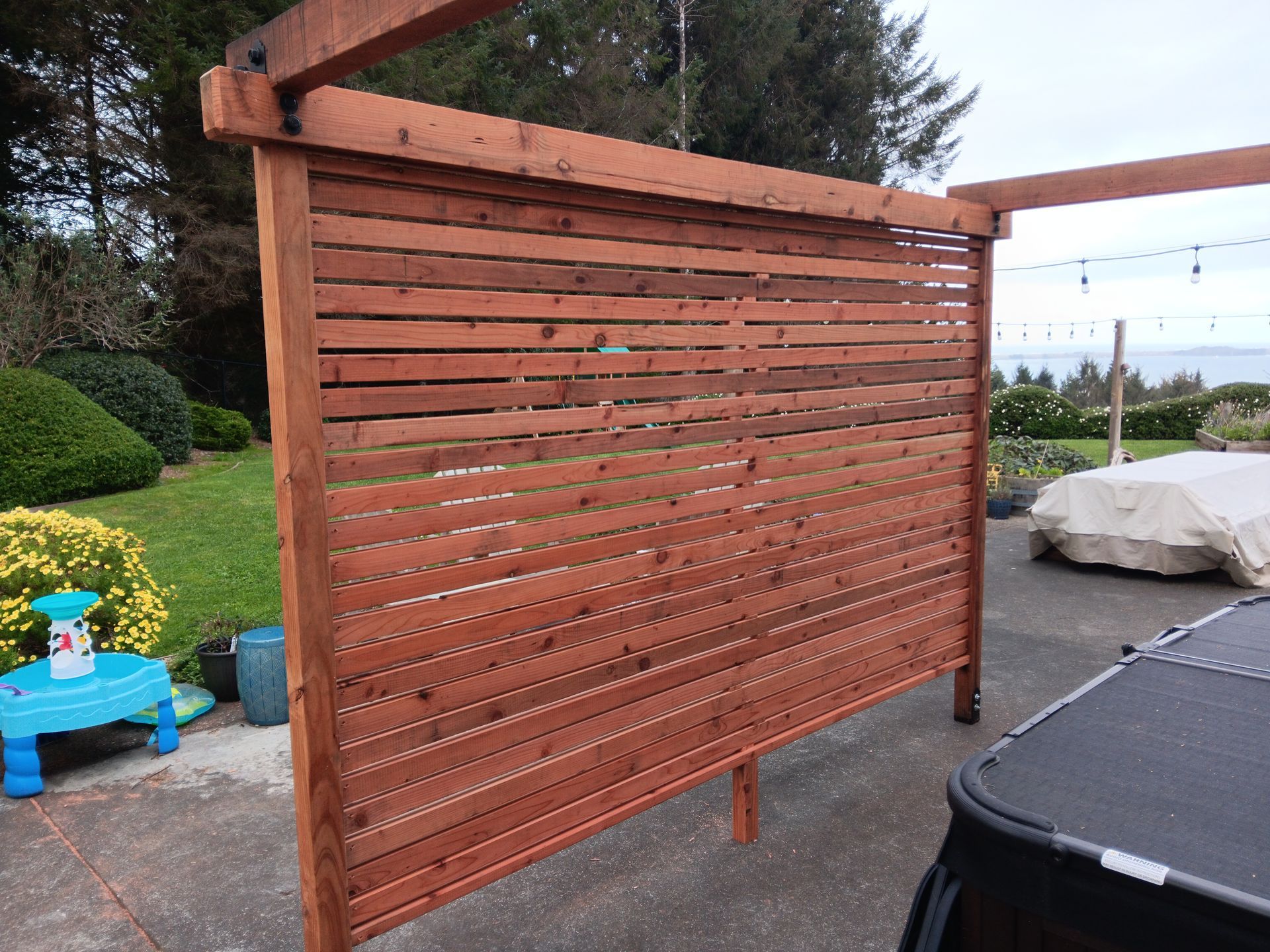 A wooden fence with a hot tub in the background