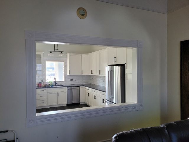 A view of a kitchen through a window in a living room