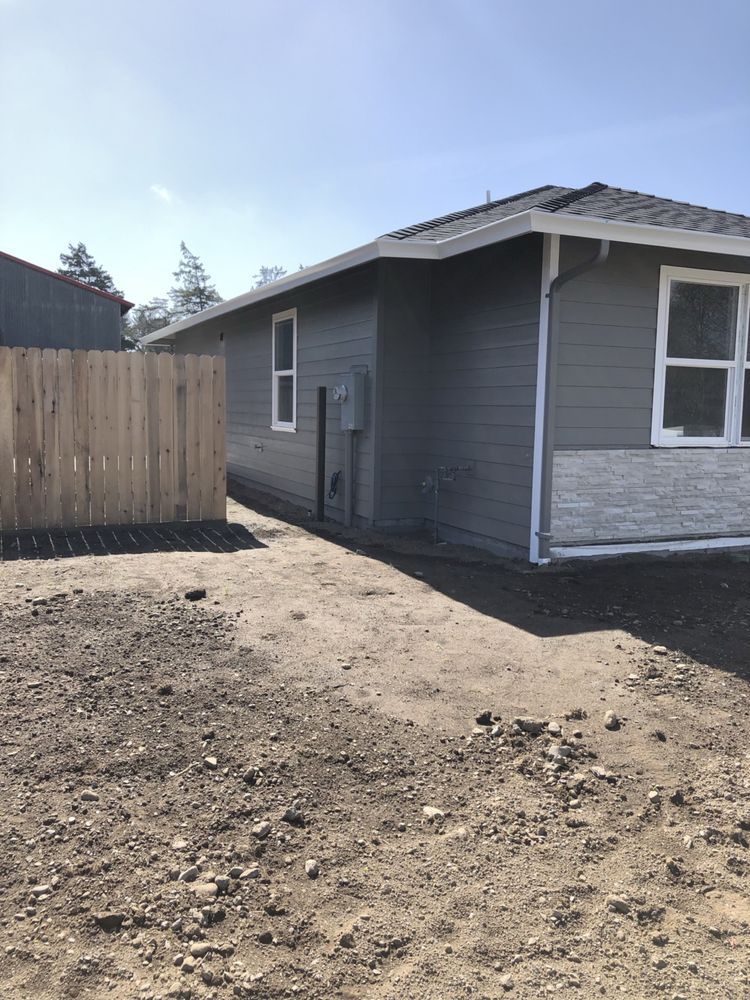 A small house with a wooden fence in front of it.