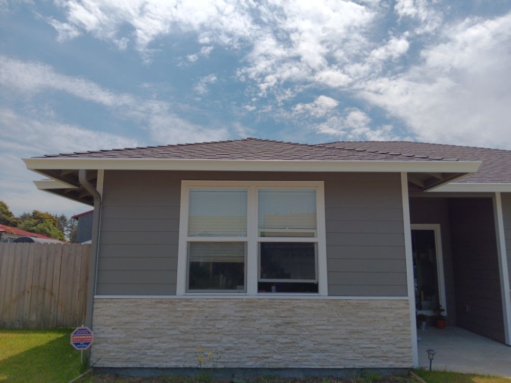 A small house with a roof and a lot of windows