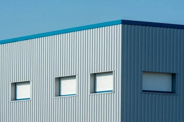 Aerial view of a large industrial warehouse with metal roofing panels and commercial building structure.