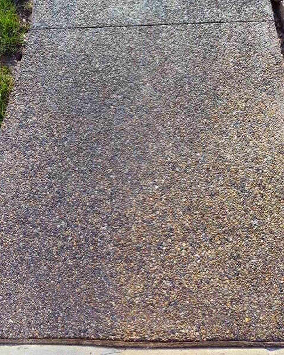 A close up of a concrete walkway with gravel on it.