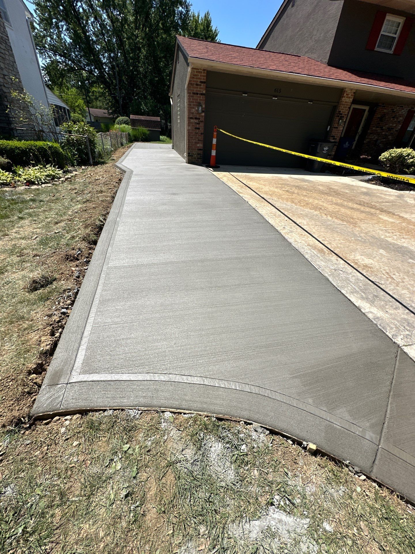 A concrete driveway is being built in front of a house.
