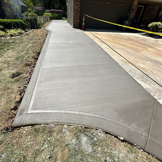 A concrete driveway is being built in front of a house.