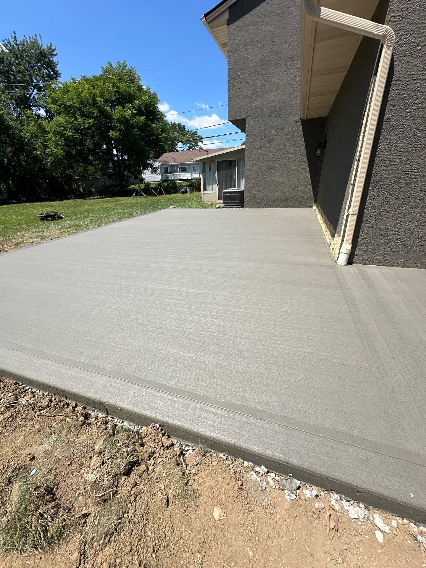 A concrete driveway is being built in front of a house