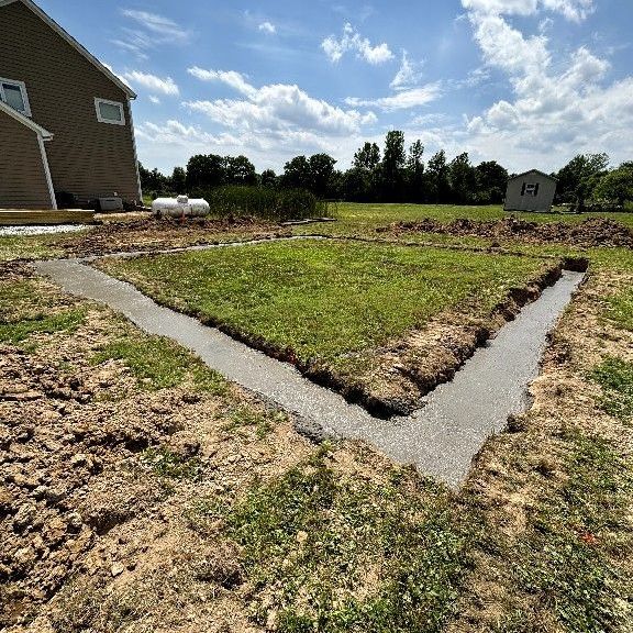 A concrete walkway with a stone wall on the side of it.