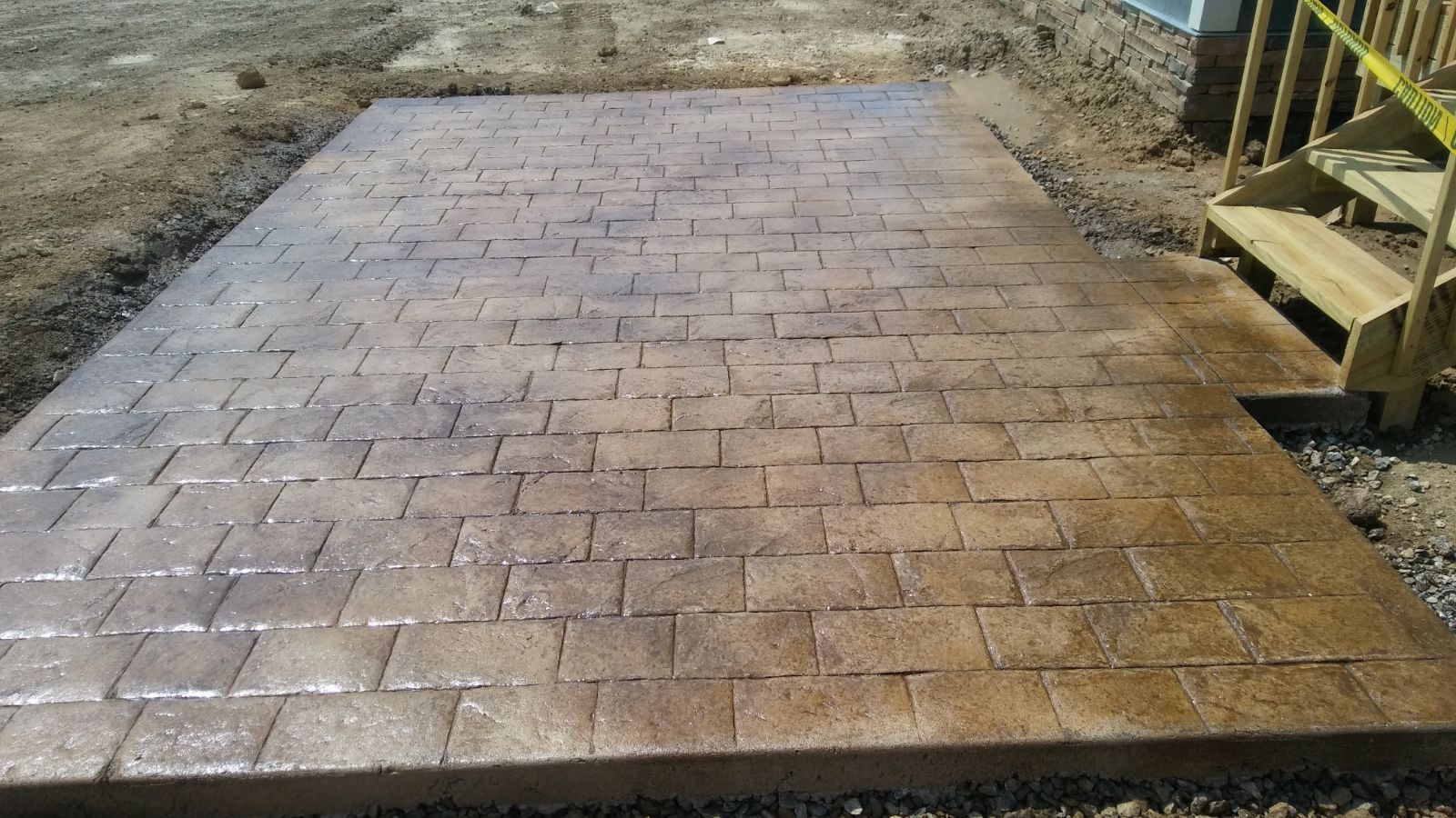A brick walkway next to a wooden staircase