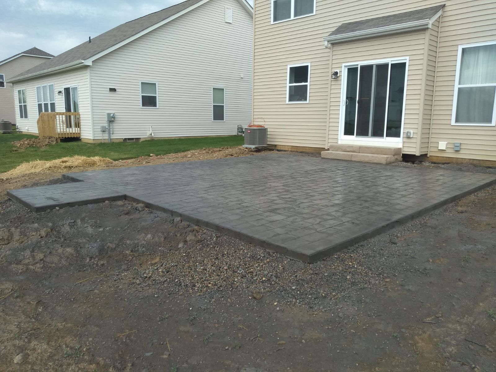 A concrete patio is being built in front of a house