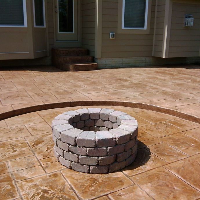 A concrete walkway with a stone wall on the side of it.