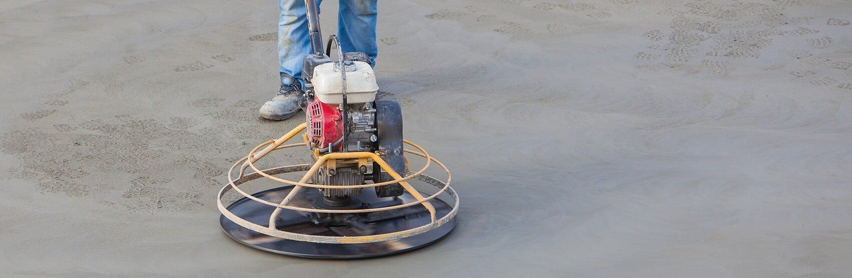 A Man Is Using A Machine To Polish Concrete On A Construction Site — JGA Concreting Pty Ltd In Berrimah, NT